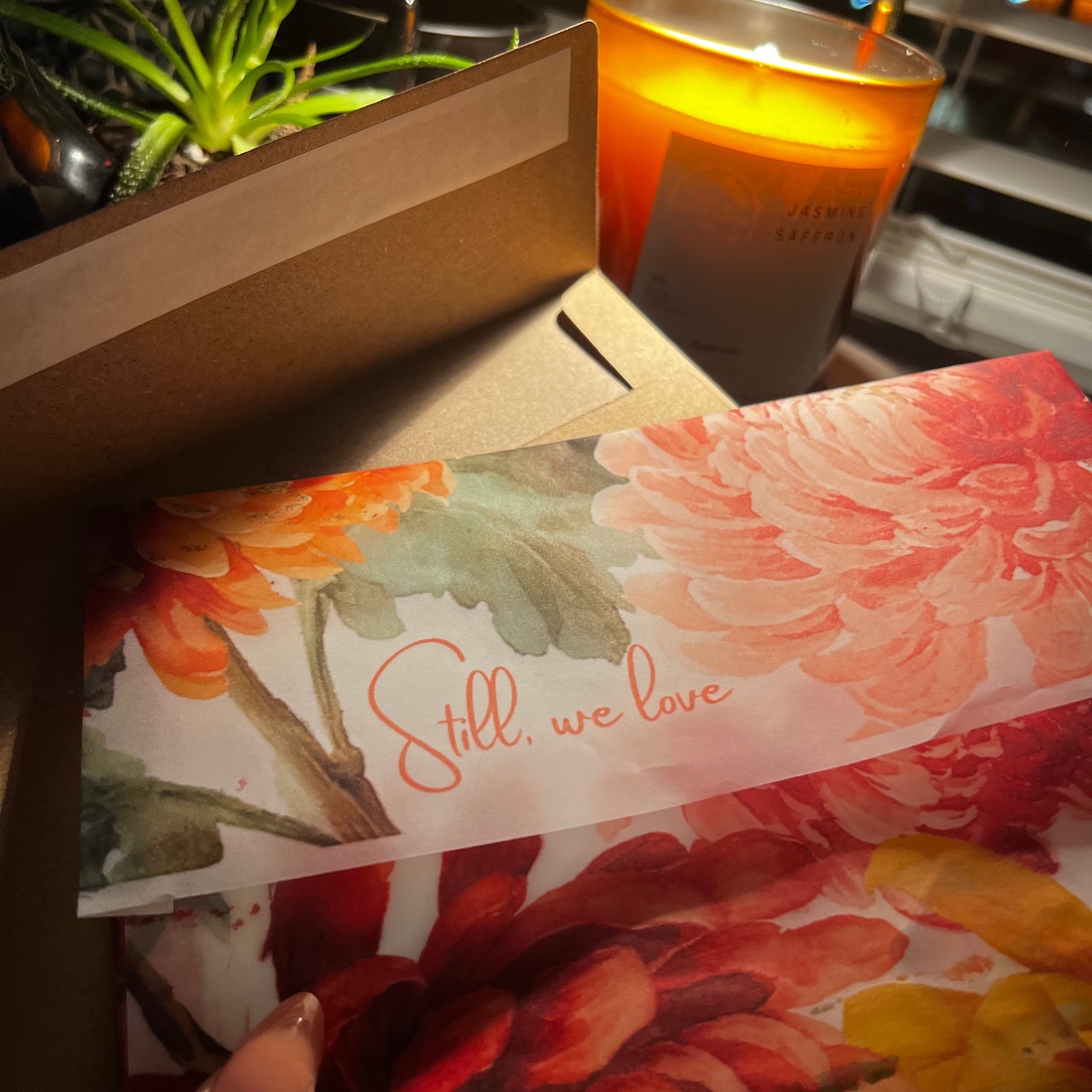 still we love envelope. background: candle and plant
